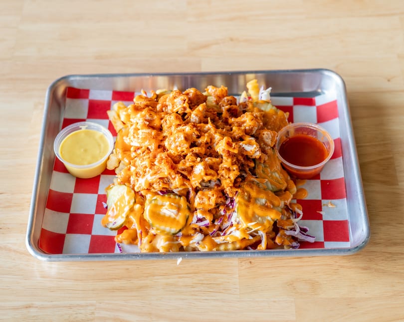 Loaded fries with crispy chicken, pickles, coleslaw, and orange sauce, served with two dipping sauces.