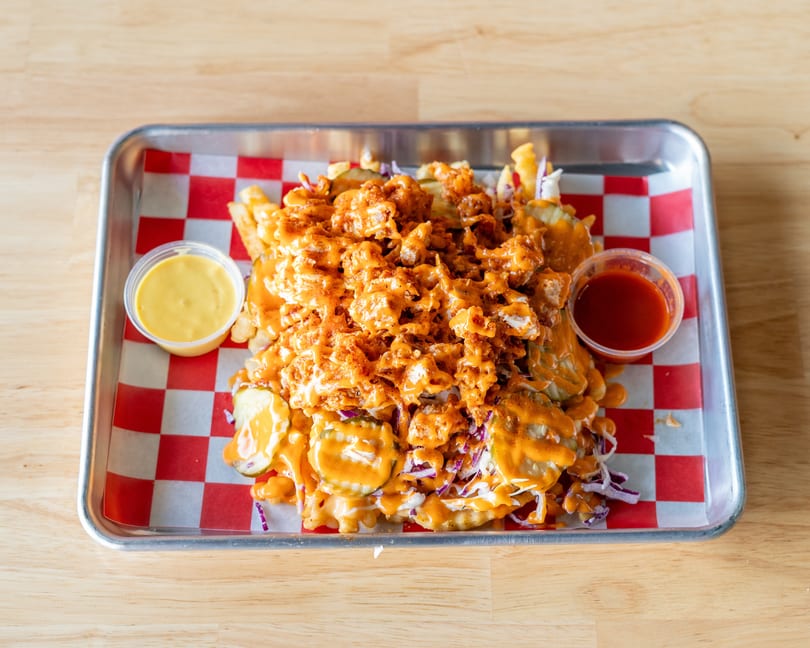 Loaded fries with crispy chicken, pickles, coleslaw, and orange sauce, served with two dipping sauces.